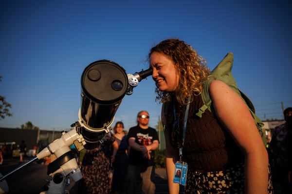 A photo of an attendee of the stargazing event at RAL looking at the solar eclipse through a telescope