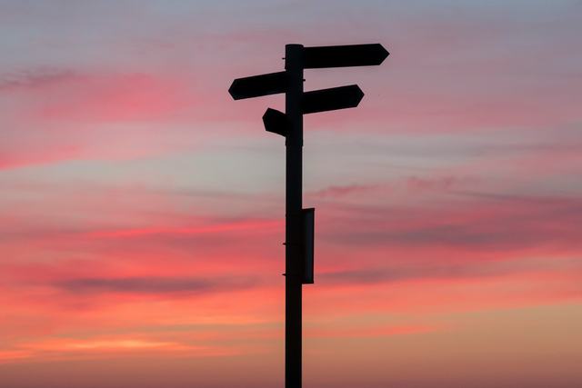 A photo of a sign against a sunset background